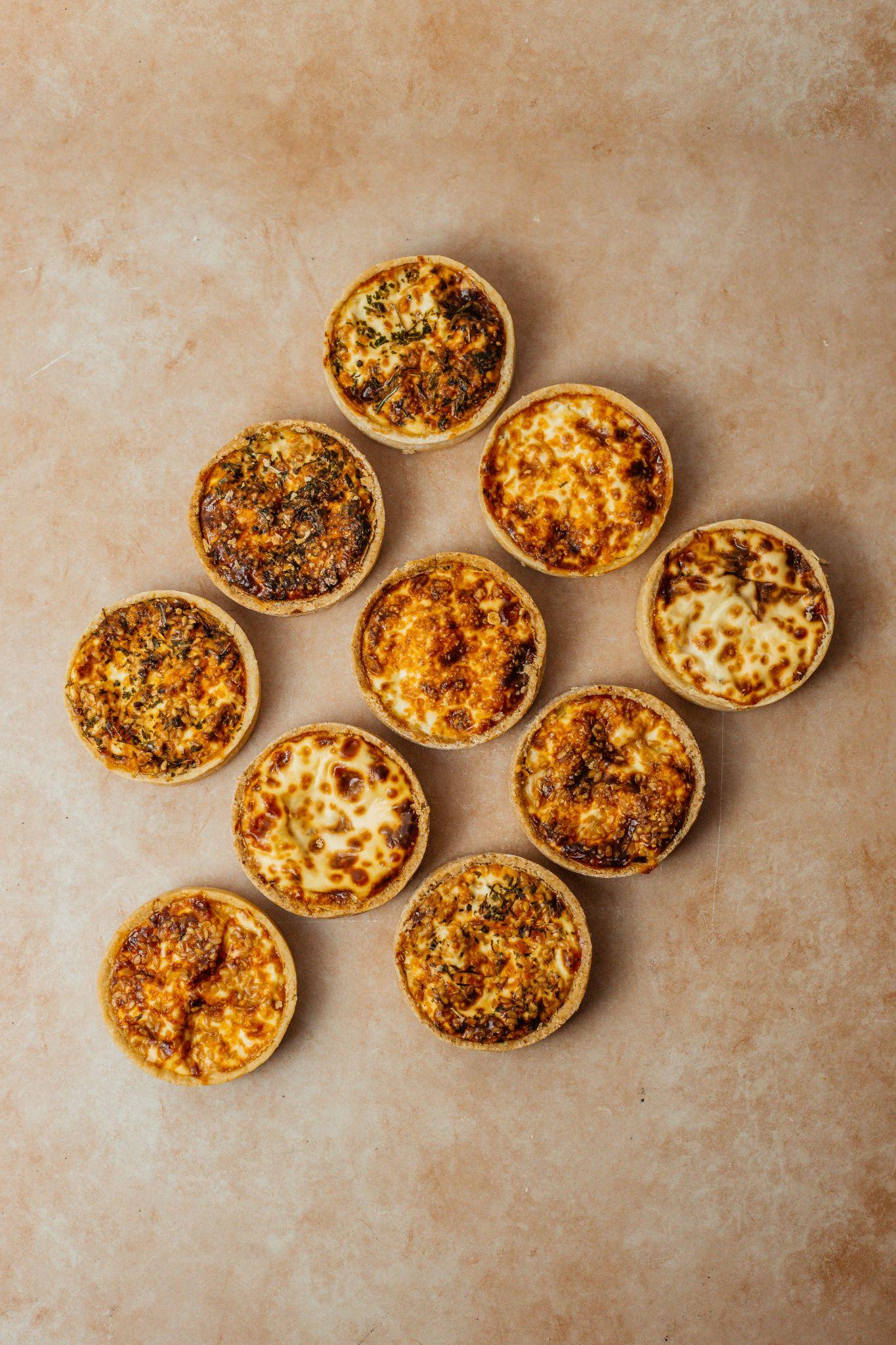 Mini tortas em disposição flat lay sobre fundo bege